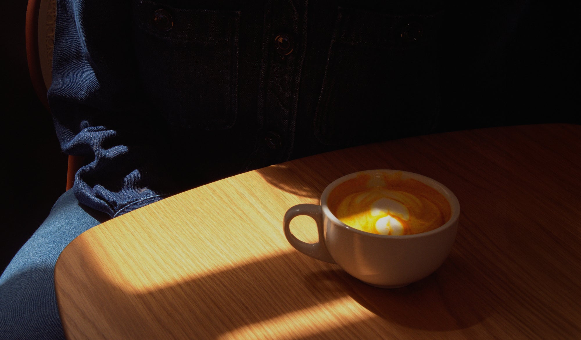 Client installé à une table de café avec un latte